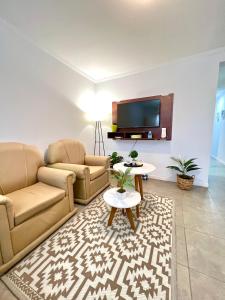 sala de estar con 2 sofás y TV en Lumiere Apartments - Luminoso Departamento en Complejo Residencial en Mendoza