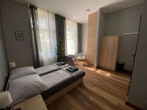 a bedroom with a bed and a room with a table at Hostel Rynek22 in Gliwice