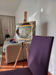a living room with a couch and a painting at Praia Azul Boutique Apartment in Vila do Conde