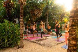 grupa kobiet uprawiających jogę na plaży w obiekcie Xtambaa Cabins & Spa Only Adults w mieście El Cuyo