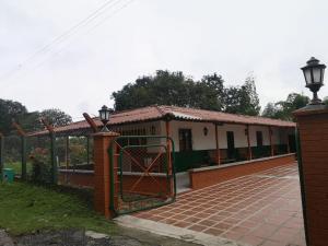 a gate to a building with a fence at Preciosa Finca en el Eje Cafetero, Quindío- Colombia in Montenegro