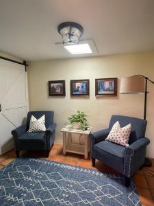 a living room with two chairs and a table at Adobe Rose Inn in Tucson