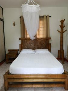 a bedroom with a bed with a curtain on it at Preciosa Finca en el Eje Cafetero, Quindío- Colombia in Montenegro
