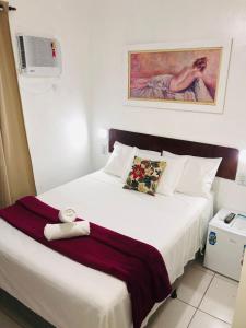 ein Hotelzimmer mit einem Bett mit einem Handtuch darauf in der Unterkunft Pousada Santé in Guarujá