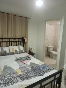 een slaapkamer met een bed en een badkamer bij Precioso apartamento, residencial Carmen Renata III,Cerca Embajada Américana in El Seis