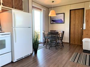 uma cozinha e sala de jantar com um frigorífico branco e uma mesa em Complexe Cap-Chat em Cap-Chat