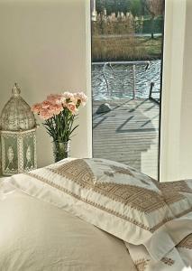 a bed with a vase of flowers next to a window at B&B Apartment Amsterdam Schiphol Airport in Hoofddorp