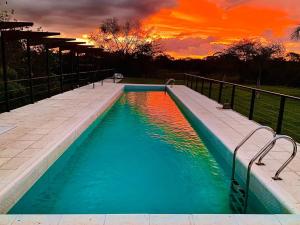 una piscina con puesta de sol en el fondo en El Descanso en Colón