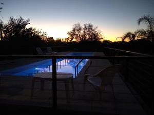 a patio with two chairs and a swimming pool at sunset at El Descanso in Colón