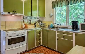 una cocina con armarios verdes y una estufa blanca en 2 Bedroom Amazing Home In Brastad, en Brastad