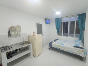 Una pequeña cocina con fregadero y refrigerador. en Apartaestudios El Descanso, en Cali