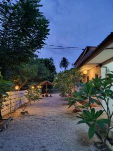 einen Garten mit einem Gebäude, Bäumen und Lichtern in der Unterkunft Seven Stones Langkawi in Pantai Cenang