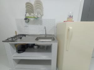 Una pequeña cocina con fregadero y refrigerador. en Apartaestudios El Descanso, en Cali 61 fotos más
