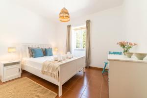 a bedroom with a white bed and a window at Quinta da Asneira in Montemor-o-Novo +157 photos