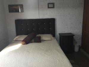 1 dormitorio con 1 cama grande y cabecero negro en Beautiful Colonial House, en Cali