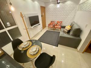 uma sala de estar com um sofá, uma mesa e cadeiras em VILA INDUSTRIAL/C/AR CONDICIONADO em Marília