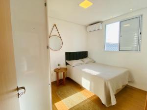Habitación pequeña con cama y ventana en VILA INDUSTRIAL/C/AR CONDICIONADO, en Marília