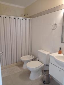uma casa de banho com um WC e uma cortina de chuveiro em Habitación de huéspedes con entrada independiente em Concordia