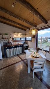 cocina grande con mesa blanca y sillas en Cabañas Bahia Serena, en Punta del Diablo