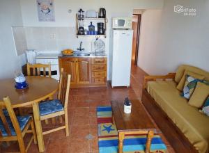 cocina y sala de estar con sofá y mesa en Complejo Dunas del Diablo en Punta Del Diablo