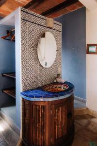 La salle de bains est pourvue d'un lavabo rond et d'un miroir. dans l'établissement HEVEN Residence, à Zipolite