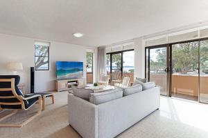 a living room with a couch and a tv at Columbia 3 large unit with fantastic water views in Nelson Bay