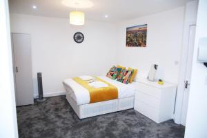 een witte slaapkamer met een bed en een klok aan de muur bij Stunning 2-Bed Apartment in Harrow in Harrow