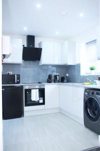 een keuken met een wasmachine en een wasmachine bij Stunning 2-Bed Apartment in Harrow in Harrow