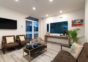 a living room with couches and a tv and a table at Aqualina Inn in San Andrés