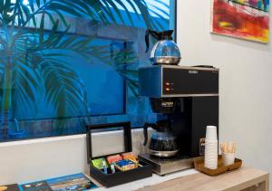 a coffee machine sitting on a table next to a wall at Aqualina Inn in San Andrés