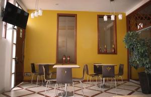 a restaurant with tables and chairs and a yellow wall at DANOBA HOTEL in Cajamarca