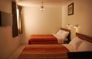pokój hotelowy z 2 łóżkami i oknem w obiekcie DANOBA HOTEL w mieście Cajamarca