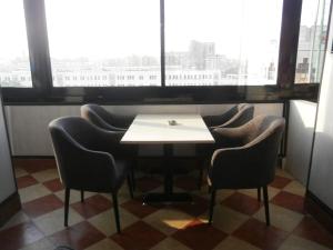 einen Tisch und Stühle in einem Zimmer mit Fenster in der Unterkunft Panorama Ramsis Hotel & Cafe in Kairo