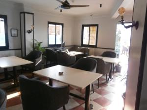 ein Esszimmer mit Tischen, Stühlen und Fenstern in der Unterkunft Panorama Ramsis Hotel & Cafe in Kairo