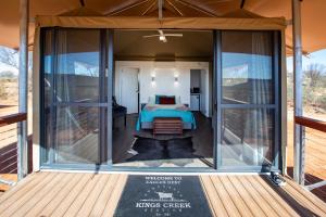 a bedroom in a tiny house with glass walls at Kings Creek Station in Kings Canyon