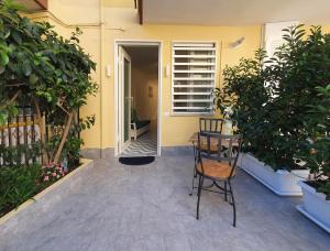 a patio with a chair and a table and some plants at La Casa di Mina in Monte di Procida