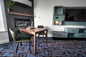 um quarto com uma mesa e duas cadeiras e uma lareira em Cannery Pier Hotel & Spa em Astoria