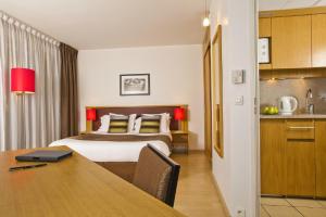 a hotel room with a bed and a desk with a table at Residhome Paris-Massy in Massy
