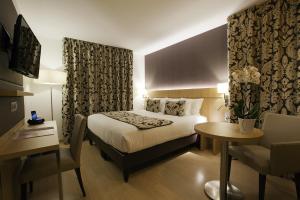 a hotel room with a bed and a table and a chair at Residhome Paris-Massy in Massy