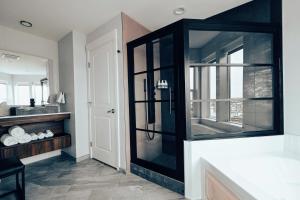 a bathroom with a glass shower with a sink at Cannery Pier Hotel & Spa in Astoria, Oregon