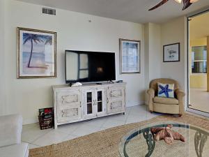 ein Wohnzimmer mit einem Flachbild-TV und einem Stuhl in der Unterkunft Beach Colony East #12D in Perdido Key