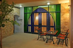 a room with a table and chairs and a stained glass window at Beit Ha'Omanim in Safed