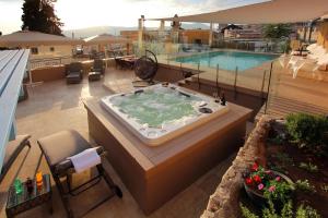 a hot tub on a balcony next to a swimming pool at Beit Ha'Omanim in Safed