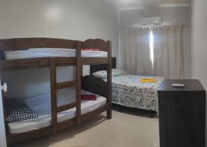 a room with two bunk beds and a table at Casa Duplex Esperança - Ar e Garagem Privativa in Bom Jesus da Lapa