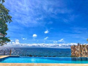 a swimming pool with a view of the ocean at 71% Diving Resort in Dumaguete