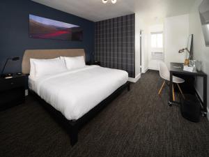 pokój hotelowy z dużym łóżkiem i biurkiem w obiekcie Motolodge w mieście Pendleton