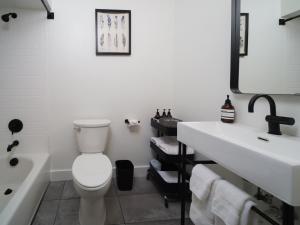a bathroom with a toilet and a sink and a tub at Motolodge in Pendleton