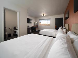 een hotelkamer met 2 bedden en een bureau bij Motolodge in Pendleton