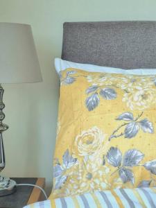 uma cama com uma almofada amarela com flores em Two Bed Holiday Home with Free Parking in Inverness em Inverness