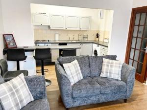 a living room with a couch and a kitchen at Two Bed Holiday Home with Free Parking in Inverness in Inverness